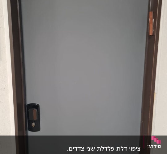 דלת אפורה עם ידית שחורה במסגרת חומה